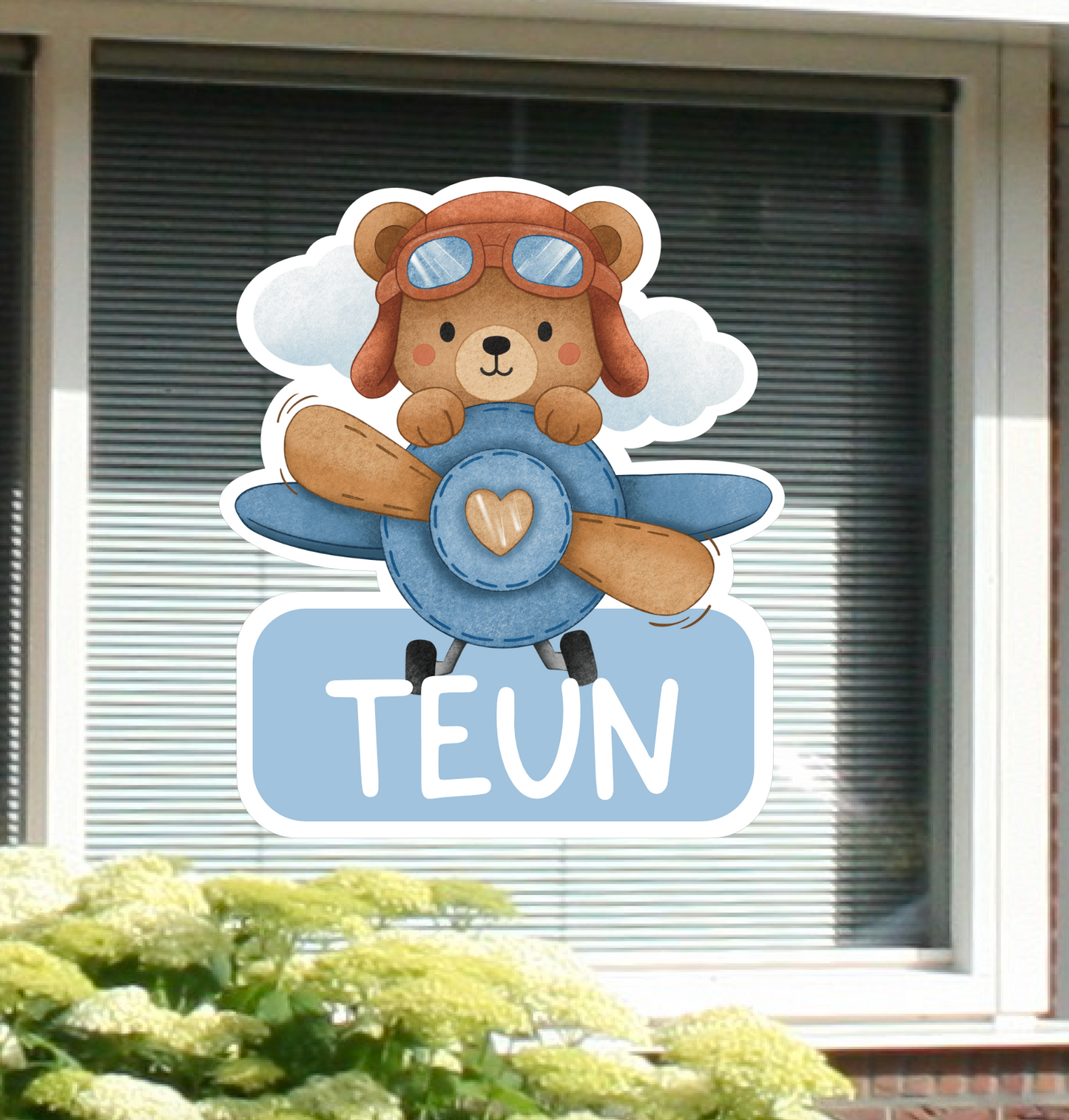 Geboortesticker voor in de tuin met de afbeelding van een beertje in een vliegtuig.