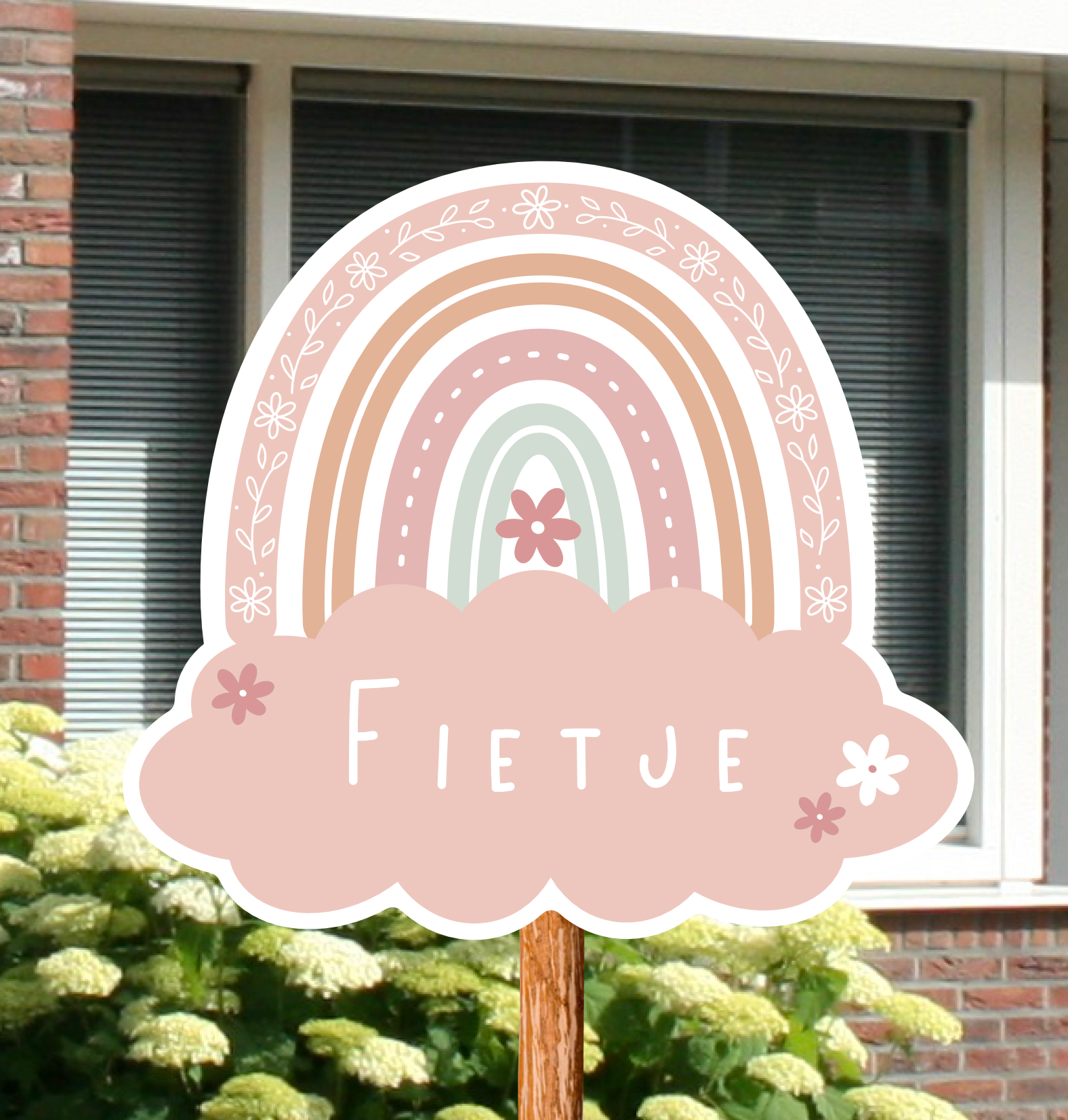 Geboortebord voor in de tuin met naam en de illustratie van een regenboog in roze kleuren.