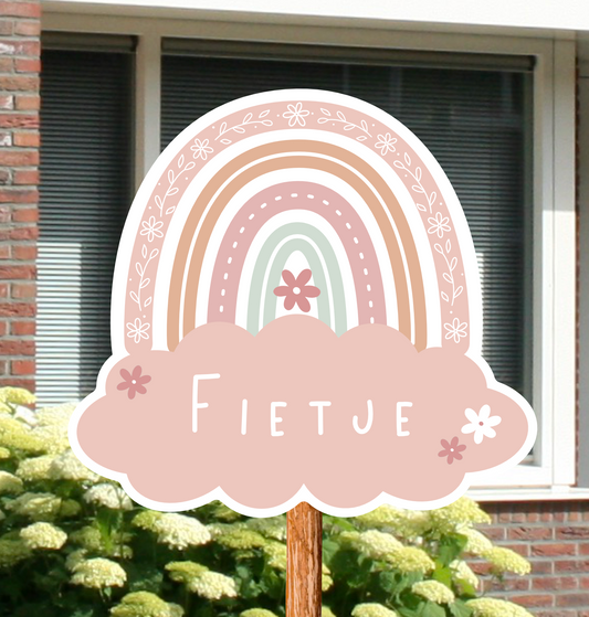 Geboortebord voor in de tuin met naam en de illustratie van een regenboog in roze kleuren.