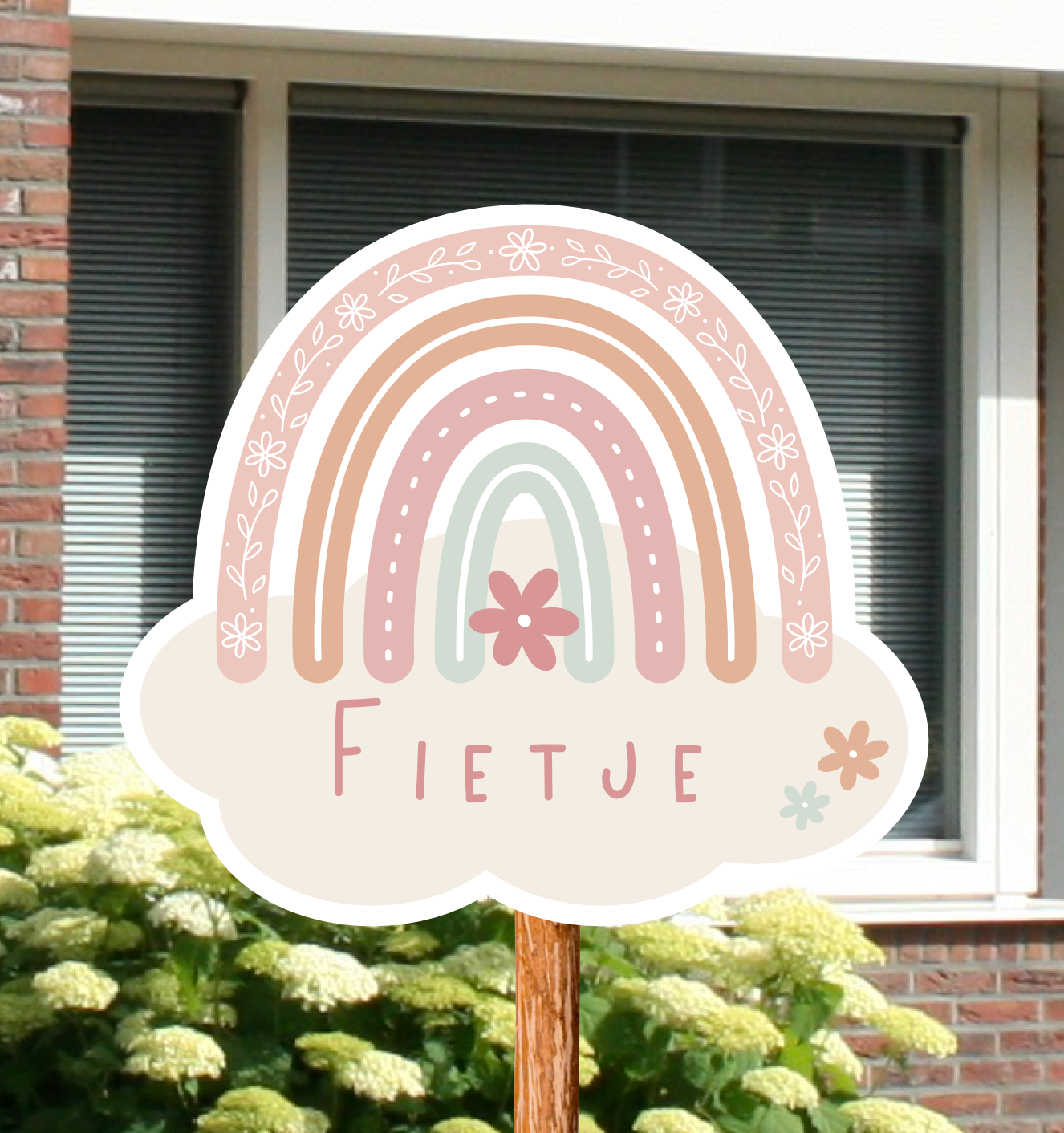 Geboortebord voor in de tuin met naam en de illustratie van een regenboog in roze kleuren.