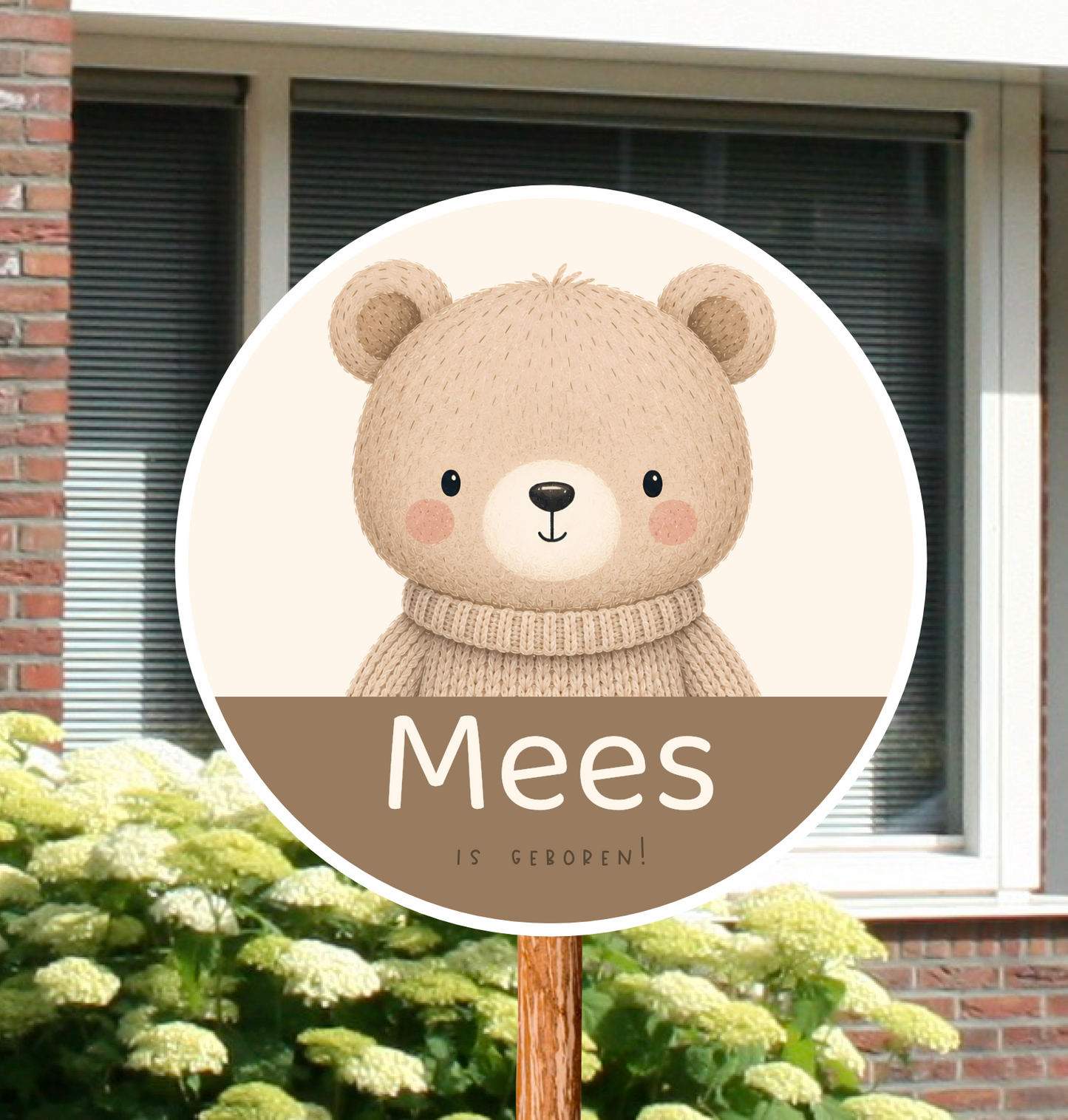 Rond geboortebord voor in de tuin, gepersonaliseerd met naam en de afbeelding van een beertje met een trui aan in beige kleuren